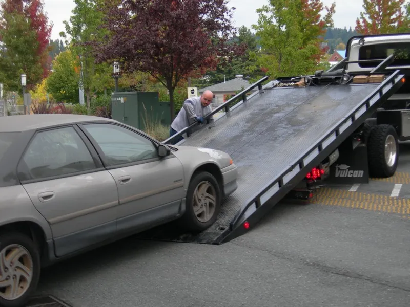Flatbed tow truck loading car — what to expect during junk car towing