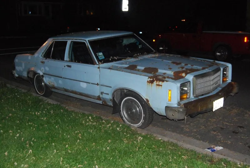 Rusty old car on driveway — when is it time to junk your car?